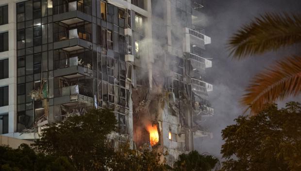 Fire and smoke rise from a building, reportedly hit by a missile fired from Iran, in central Tel Aviv on June 13, 2025. Iran fired a barrage of ballistic missiles at Israel in a counter-strike in the evening on June 13, after an unprecedented onslaught hammered the Islamic republic's top military brass and targeted its nuclear facilities and bases. (Photo by Jack GUEZ / AFP)