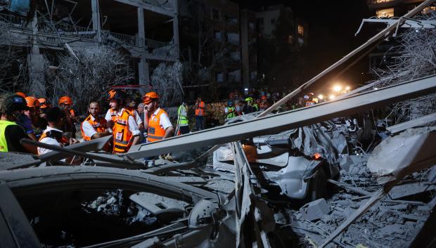 EDITORS NOTE: Graphic content / Israeli first responders arrive at a site hit by a missile fired from Iran, in Ramat Gan on the outskirts of Tel Aviv on June 13, 2025. Iran fired a barrage of ballistic missiles at Israel in a counter-strike on June 13, after an unprecedented onslaught hammered the Islamic republic's top military brass and targeted its nuclear facilities and bases. (Photo by GIL COHEN-MAGEN / AFP)