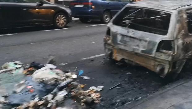 Incendio de un cubo de basura con un coche cerca, muy habitual