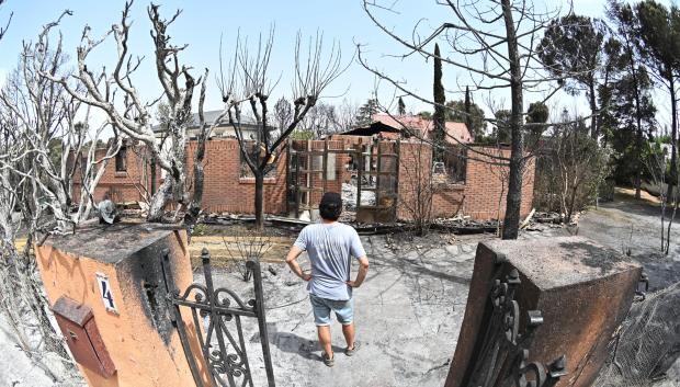Un hombre contempla una zona afectada por el incendio que desde ayer afecta a la localidad de Tres Cantos