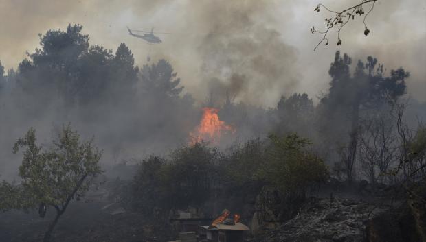 Un helicóptero trata de extinguir el incendio, a 12 de agosto de 2025, en Seixalbo