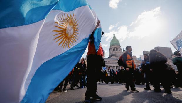 Una persona sostiene una bandera de Argentina durante una manifestación