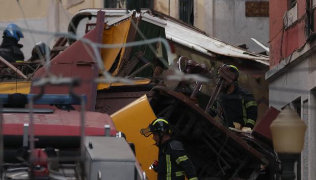Policías y bomberos trabajan en el lugar del accidente de funicular en Lisboa