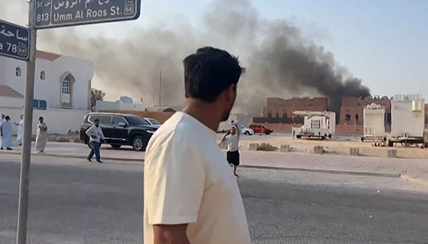 Captura de pantalla que muestra a un hombre observando una columna de humo tras las explosiones en Qatar