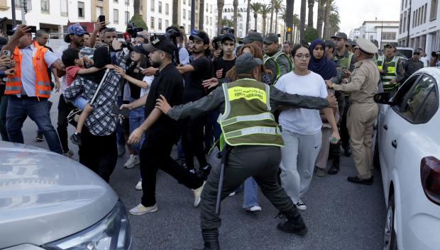 Miembros de las fuerzas de seguridad detienen a un manifestante mientras otros se pelean durante una manifestación liderada por jóvenes en Rabat