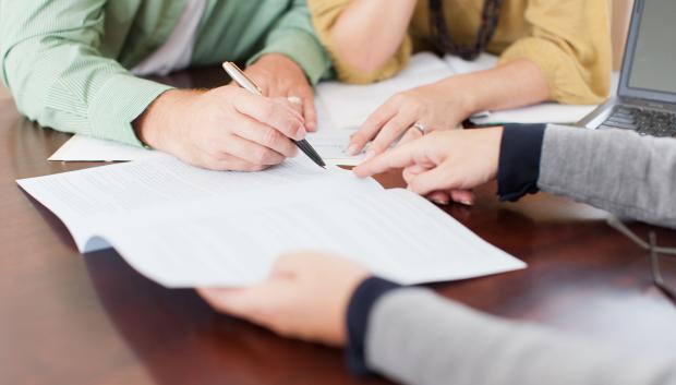 Pareja firmando un préstamo hipotecario