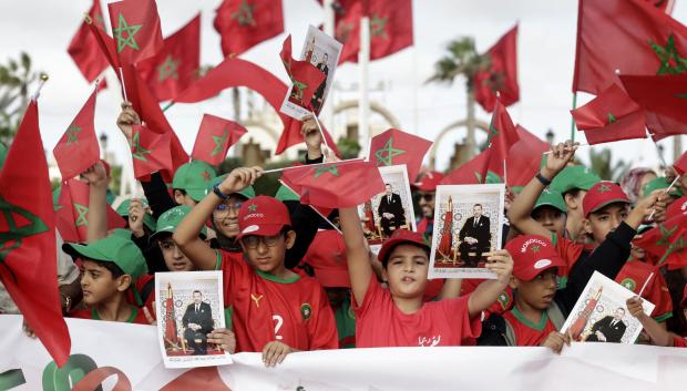 Niños ondean banderas marroquíes y portan retratos del rey Mohammed VI durante las conmemoraciones de la llamada Marcha Verde de 1975