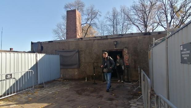 Visitantes saliendo de los crematorios del campo de concentración de Auschwitz, estructura que conserva la chimenea