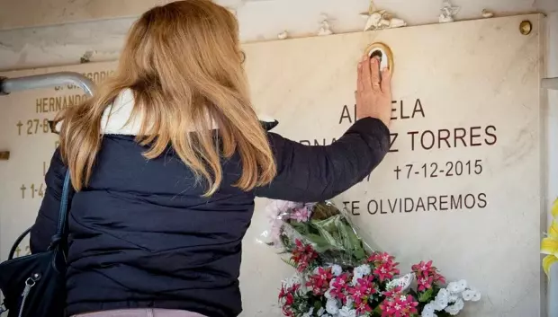 Imagen de archivo de una familiar ante una sepultura en el cementerio
