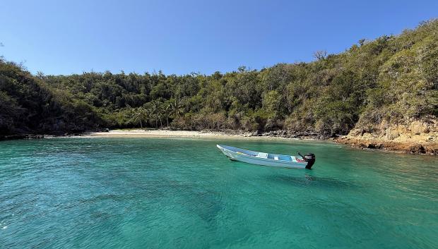 Cala con un barco de paseo.