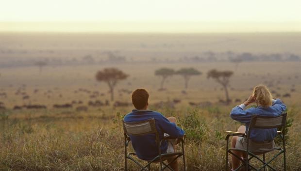 Una pareja contempla la sabana de Tanzania durante su viaje de Luna de Miel.