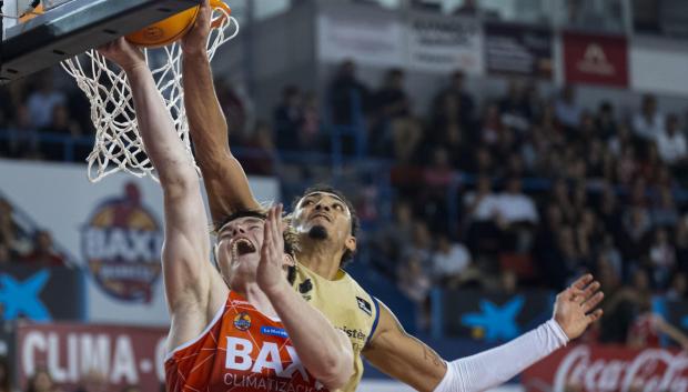 El ala-pívot estadounidense del Barcelona Miles Norris (d) tapona al ala-pívot letón del Baxi Manresa Marcis Steinbergs (i)