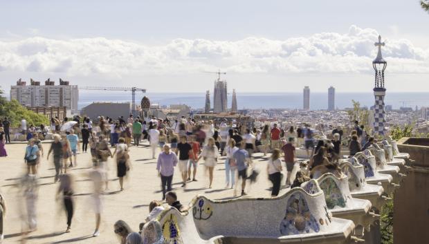 Vecinos y turistas en el Park Güell de Barcelona contemplan una panorámica de la ciudad