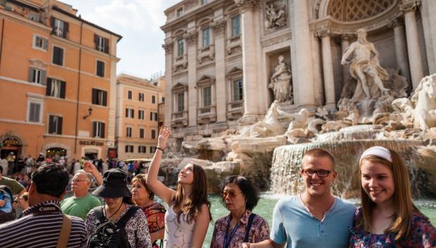 Turista lanzando una moneda a la Fontana di Trevi.
