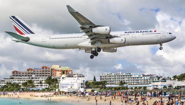 Enorme avión comercial sobre los turistas de Maho Beach