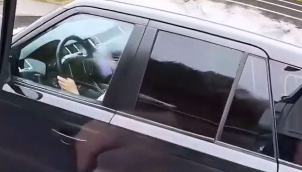 El conductor de un turismo escribiendo en el móvil