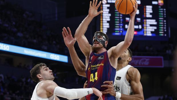 El alero del Barça, Joel Parra (c) trata de anotar ante el Real Madrid durante el partido de la ACB