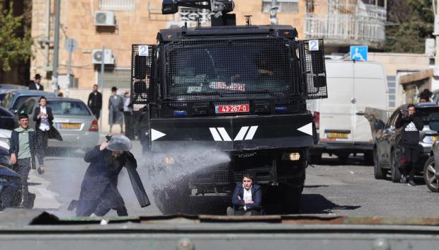 La policía utiliza cañones de agua contra manifestantes judíos ultraortodoxos durante una protesta contra la ley de reclutamiento militar israelí en Jerusalén,