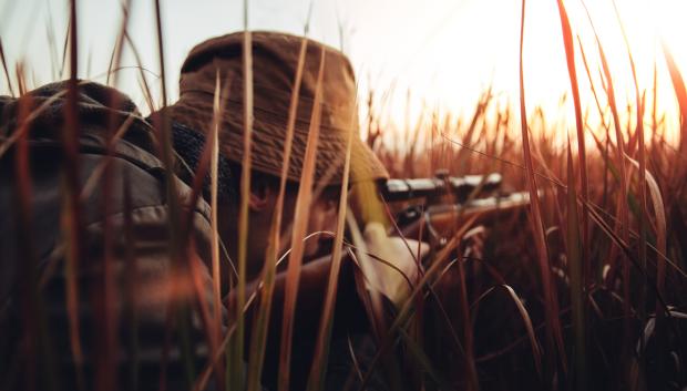 Cazador tendido sobre la sabana africana
