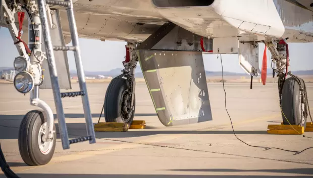 El modelo de prueba de flujo laminar natural atenuado por flujo cruzado de la NASA se monta debajo del avión de investigación F-15 de la agencia antes de la prueba de rodaje a alta velocidad del diseño