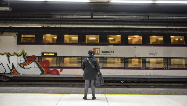 Una mujer espera un tren de Rodalies, en la estación de Sants de Barcelona