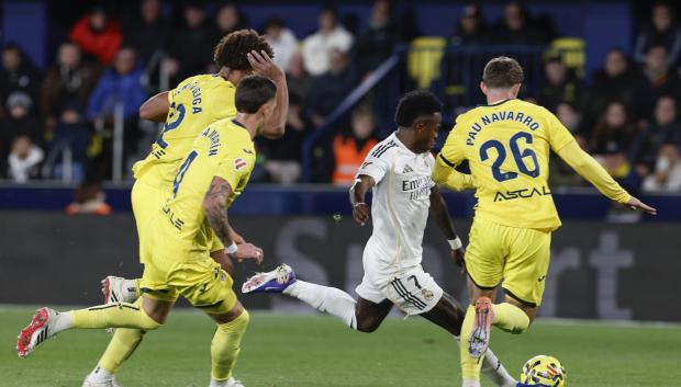 El delantero del Real Madrid Vinicius Jr. centra el balón junto a Pau Navarr