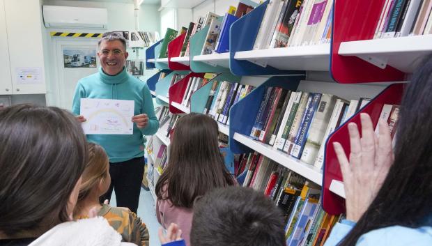 José Manuel Rodríguez recibe un dibujo de agradecimiento de los escolares del centro escolar de Villalba de los Alcores en su último día de ruta por su jubilación