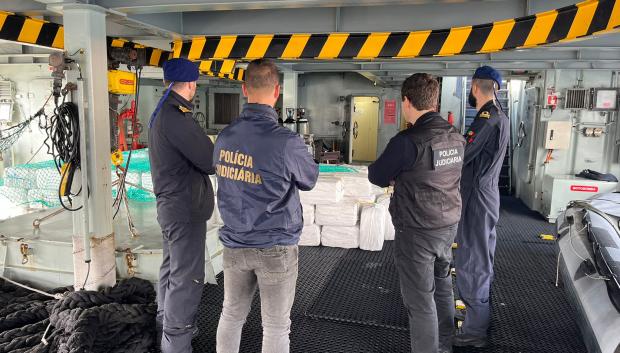 Agentes de policía junto a paquetes de cocaína incautados en un semisumergible