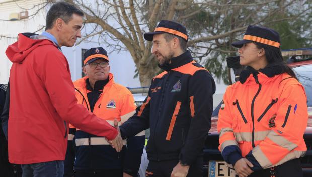El presidente del Gobierno, Pedro Sánchez (i), conversa con miembros de Protección Civil durante la visita que ha realizado al Campo de Gibraltar