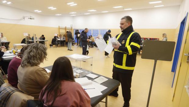Un empleado de Correos entrega los votos por correo en un colegio electoral este domingo en Zaragoza