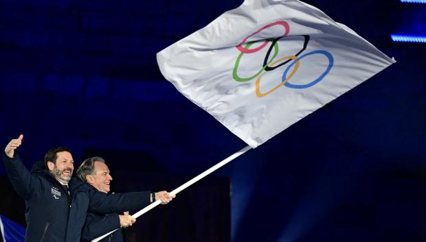 Provence-Alpes-Cote dAzur regional president Renaud Muselier and Auvergne-Rhône-Alpes regional president Fabrice Pannekoucke (L) wave the Olympic flag during the flag handover ceremony to the next host of the 2030 Winter Olympics, the French Alps, at the closing ceremony of the Milano Cortina 2026 Winter Olympic Games at the Verona Arena in Verona, northern Italy, on February 22, 2026. (Photo by Stefano RELLANDINI / AFP)