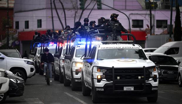 Mexican National Guard special forces patrol around the Specialized Prosecutor's Office for Organized Crime (FEMDO) headquarters in Mexico City on February 22, 2026. Mexico confirmed on February 22, 2026, that soldiers killed a powerful drug cartel leader who was one of the most wanted men here and in the United States. Nemesio Oseguera, the 59-year-old leader of the violent Jalisco New Generation Cartel, was wounded in a clash with soldiers in the town of Tapalpa and died while being flown to Mexico City, the army said in a statement. (Photo by Alfredo ESTRELLA / AFP)