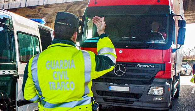 Un agente hace indicaciones al conductor de un camión