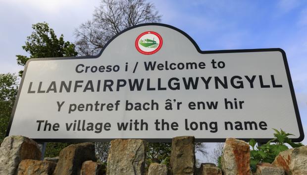 Cartel de bienvenida a la localidad con el nombre abreviado