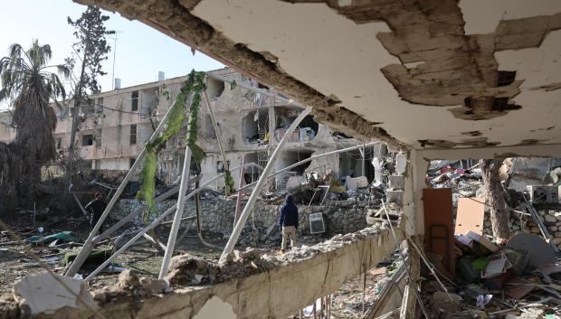 Varias personas observan el lugar donde un misil iraní impactó directamente en un barrio residencial de Dimona, al sur de Israel