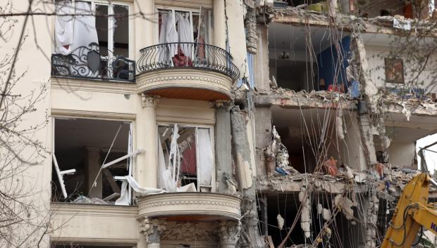 Cortinas rasgadas cuelgan de las ventanas de un edificio residencial destruido en el norte de Teherán