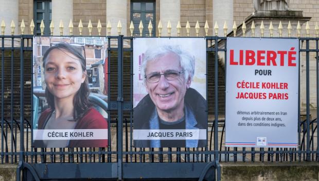 Carteles con los retratos de Cecile Kohler y Jacques Paris, dos ciudadanos franceses que estuvieron detenidos en Irán