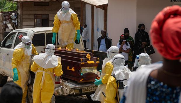 Personal sanitario con EPI completo se prepara para trasladar el cuerpo de una víctima de ébola