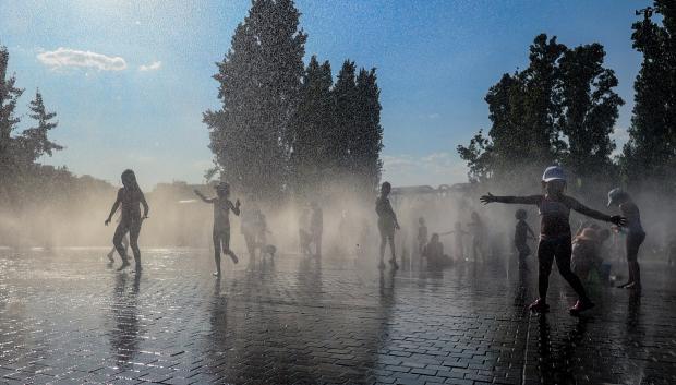 Varios niños se refrescan en una fuente durante la tercera ola de calor en Madrid
