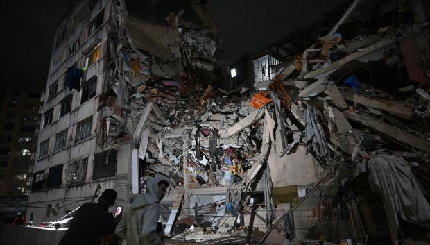 Unas personas observan un edificio derrumbado en el barrio de Altamira (Caracas)