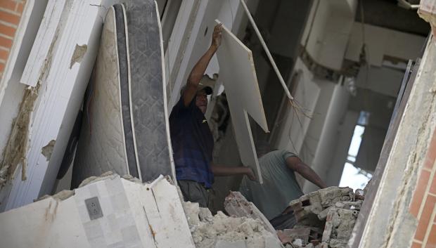 Una persona levanta un panel mientras busca entre los escombros en el interior de un edificio gravemente dañado tras un terremoto en Catia La Mar, estado de La Guaira.