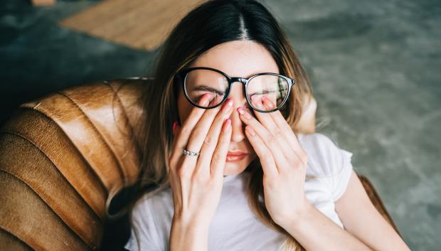 Mujer joven se frota los ojos