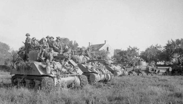 Tanques Sherman que transportan infantería esperan la orden de avanzar al comienzo de la Operación Goodwood