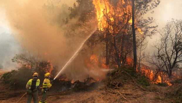 Los bomberos combaten un incendio que rodea la zona residencial de La Atalaya, en El Tiemblo, a 80 km al oeste de Madrid, el 25 de julio de 2026, en medio de los incendios forestales que han arrasado hasta 25 000 hectáreas.