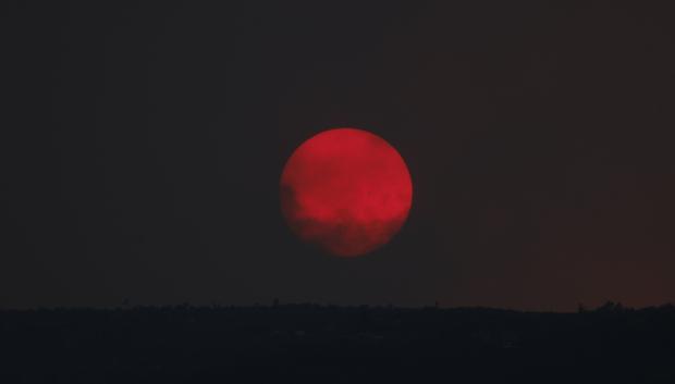 El sol rojizo en medio de un incendio forestal en Burgohondo