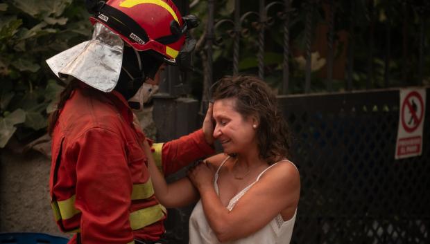 Una efectivo de la UME consuela a una vecina de Piedralaves tras quemarse la casa de su padre durante el incendio de Burgohondo