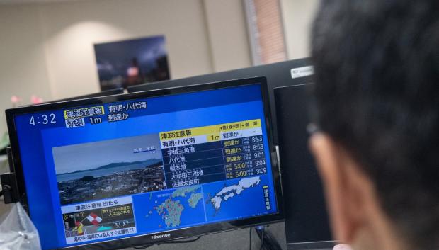 Unos periodistas observan las noticias sobre un fuerte terremoto y la posible llegada de un tsunami con olas de un metro al sur de Japón