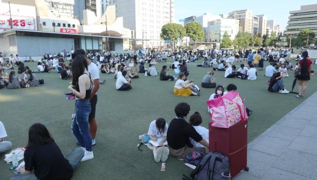 Personas se reúnen frente a un edificio tras un fuerte terremoto en la ciudad de Kumamoto, Japón