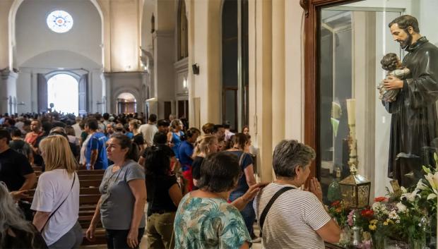 Fieles rezan ante la imagen de San Cayetano en el santuario de Liniers, en Buenos Aires, uno de los principales centros de devoción popular al santo del pan y del trabajo en Argentina.