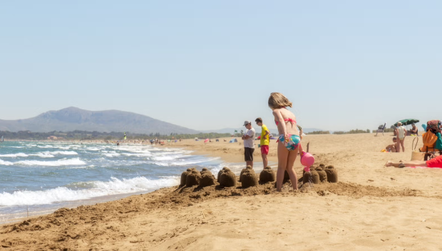 Imagen de una nena jugando en la playa de La Devesa, Valencia